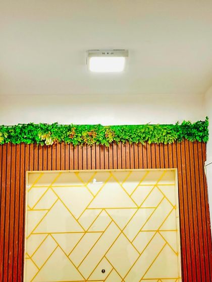 A green wall doesn't have to cover the entire wall. Here, we installed a horizontal strip of greenery above a decorative panel, acting as a unique, maintenance-free cornice.