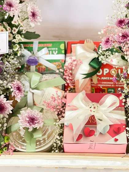 This view of the anniversary hamper highlights the edible treats, including a tres leches bento cake, ready to be devoured.