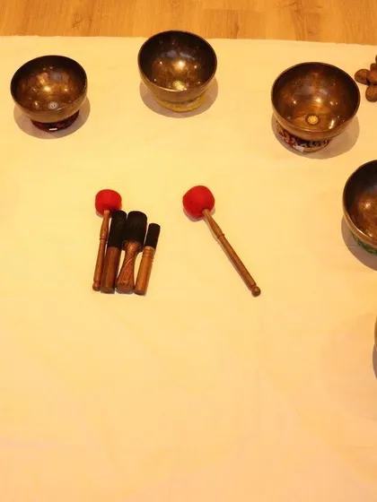 Here is the setup for one of my sound healing sessions. Each Tibetan bowl is chosen for its unique frequency, and they are arranged with mallets and other instruments like rainsticks to create a rich soundscape.