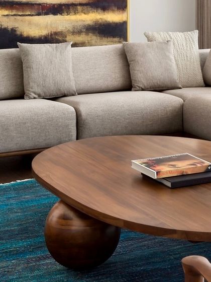 The beauty of natural wood is highlighted in this close-up of the oval coffee table in the West Coast Residence. The rich grain and smooth finish invite touch.