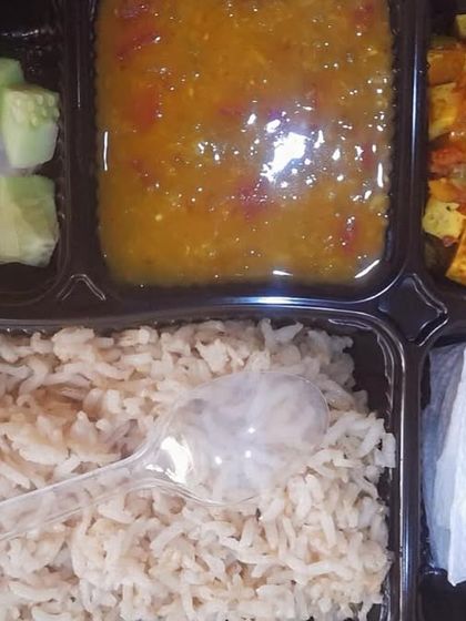 A healthy thali featuring dal, tofu paneer, and brown rice. This is a great option for vegans or those looking for a lighter protein source.