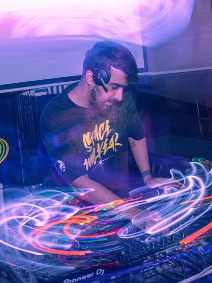 A long-exposure shot creating light trails around me at the console. This artistic photo captures the flow of energy and music.