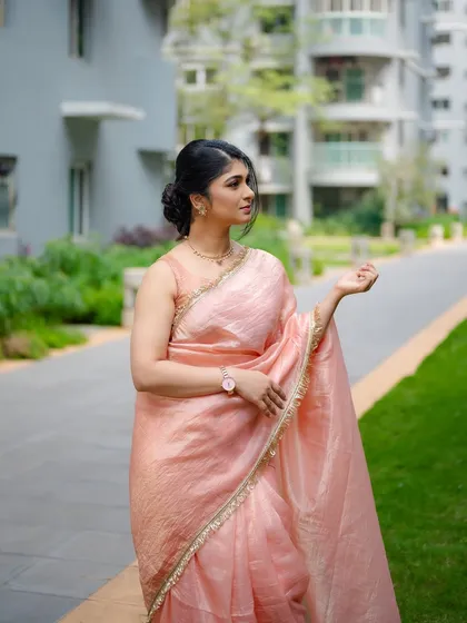 A candid portrait of actress Aditi Prabhudeva in a peach saree. The soft, natural light and her gentle expression create a warm and beautiful image.