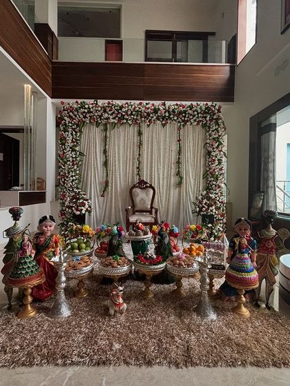 A wider shot of the home engagement decor, showing the full floral arch and offering table arrangement.