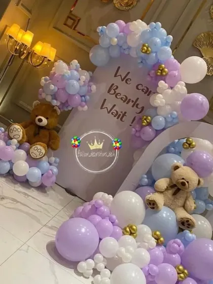 A dreamy teddy bear baby shower theme in pastel purple, blue, and white. This "We Can Bearly Wait" setup features two arches and teddy bears nestled in balloon clouds.