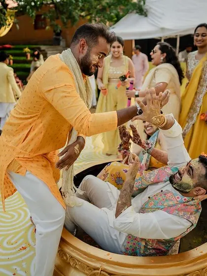 The Haldi ceremony gets playful as the groom is covered in turmeric paste by his friends and family.