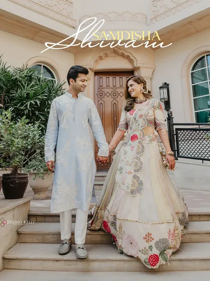 A beautiful shot of the couple holding hands and walking down the steps of the ITC Grand Bharat.