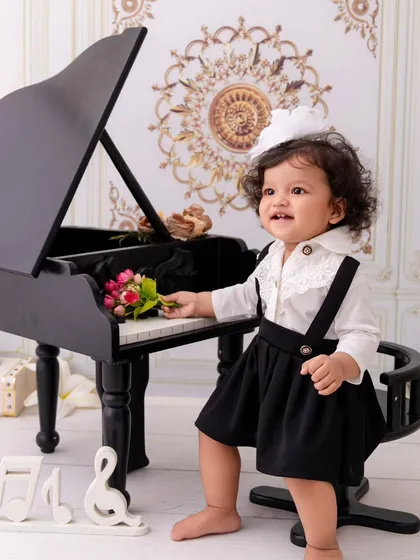 A little maestro in the making. This portrait captures a child's natural curiosity as she explores the miniature piano.