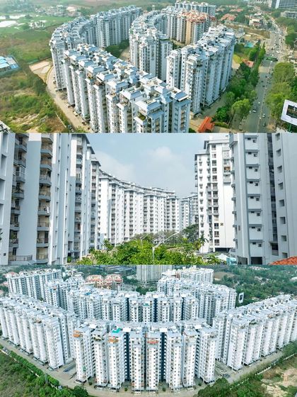 An aerial shot showcasing the unique C-shaped architecture of a large apartment complex by Pranav Constructions, demonstrating how drone photography can reveal a building's design.