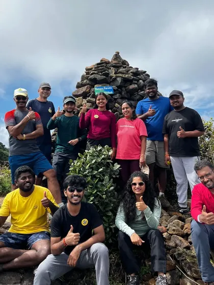 A happy and energetic group giving a thumbs-up at the summit. The positive vibe is contagious.