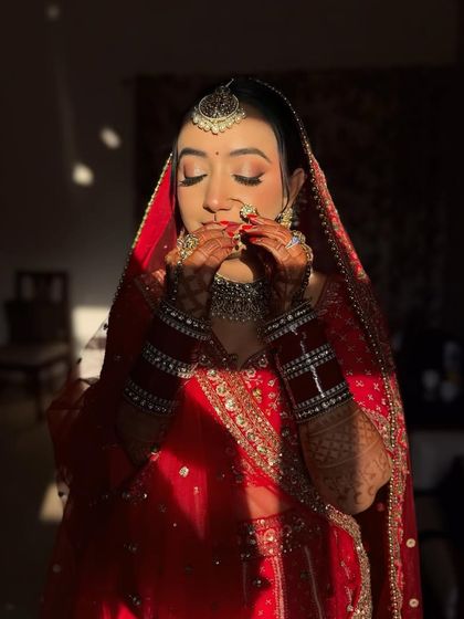The ultimate red bridal look, captured in the golden hour sun. The light catches the highlighter beautifully, creating a divine glow.