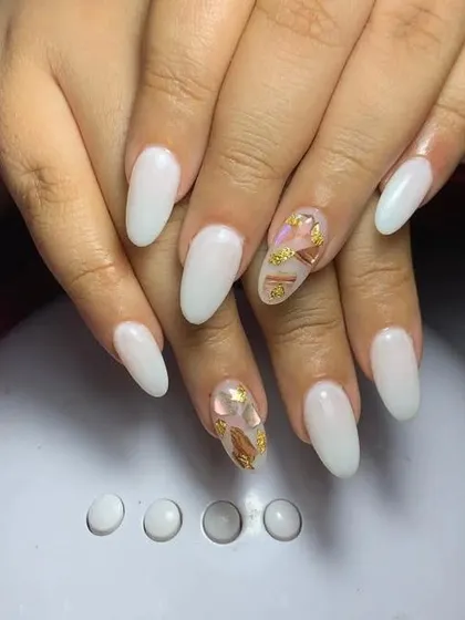 A simple and elegant set of milky white nails with gold foil accents on two nails.