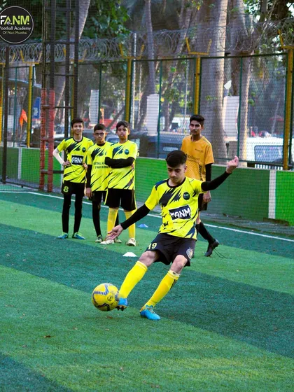A player practices his shooting technique, aiming for the corner of the goal.
