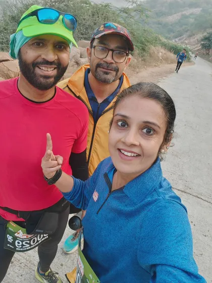 A selfie of three runners mid-race on the Aravali trail. The camaraderie on the course is just as important as the finish time.