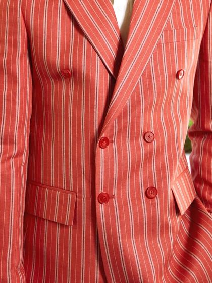 The bold stripes and double-breasted design of this linen jacket make it a standout piece for the fashion-forward man.