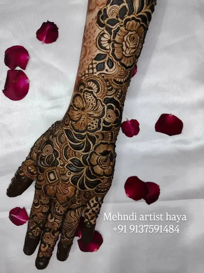 A stunning full-hand design captured with rose petals, emphasizing the romantic and celebratory nature of bridal henna.