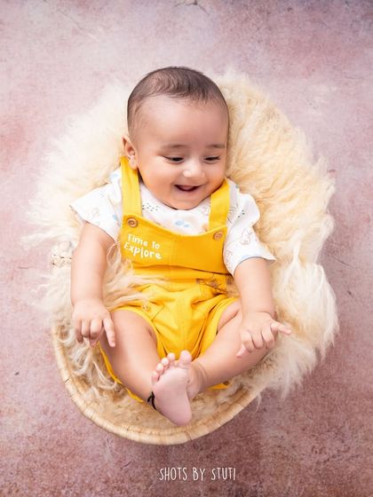 Another shot from a 3 month session. This baby is looking down at his toes with a sweet smile. These sessions are great for capturing their growing awareness and playful nature.