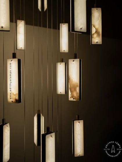 These modern pendants feature a unique combination of translucent marble and stitched leather accents. The warm light glows through the marble, creating a sophisticated and texturally rich fixture for contemporary spaces.