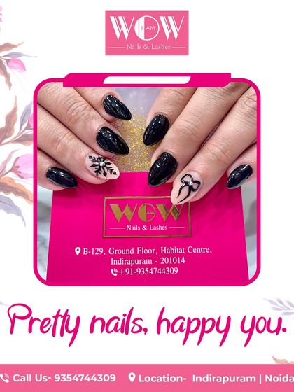 A chic and edgy design featuring a matte black polish with a delicate bow and snowflake design on a neutral accent nail.