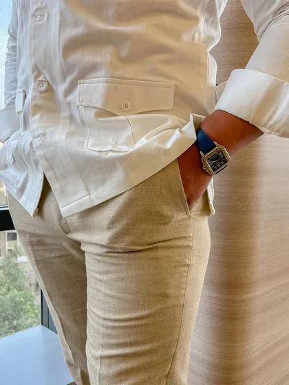 A closer look at the safari shirt and linen trousers. The fit is relaxed for comfort, but the tailoring is precise, ensuring a smart silhouette.