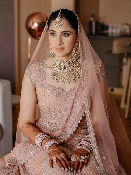 A seated portrait of the bride, looking serene and beautiful in her pastel Phera outfit.