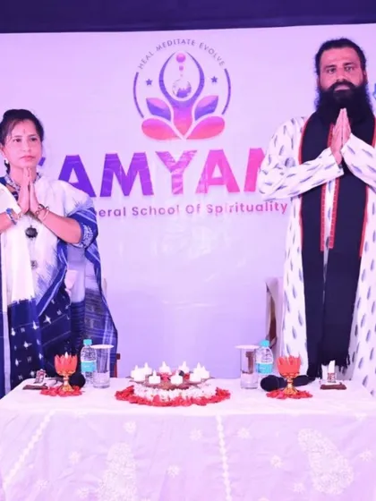 We stand in a gesture of 'Namaste' at an event, with our 'Liberal School of Spirituality' banner in the background. This photo represents our core philosophy of offering accessible spiritual guidance.