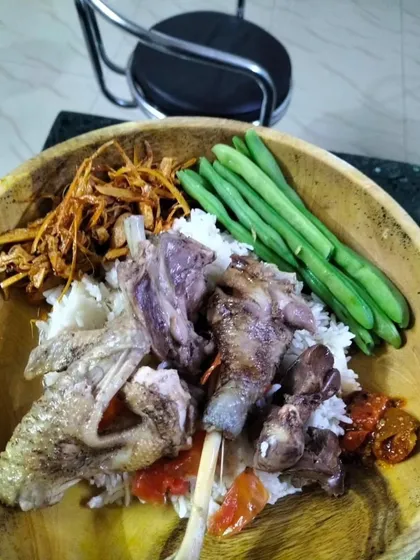 A simple, rustic meal of local chicken served with rice, boiled beans, and fried bamboo shoots. This is pure, unpretentious home-style cooking.