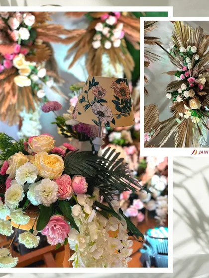 A close-up of the rustic floral arrangements, showing the beautiful combination of dried palms, pampas grass, and fresh roses. The floral lampshade is a unique, custom touch.