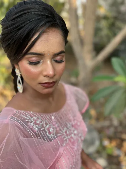 An outdoor shot in the golden hour light. The highlighter on her cheekbones catches the sun beautifully, creating a stunning glow.