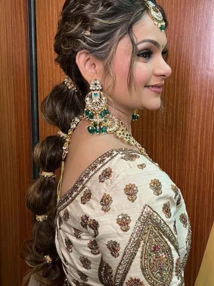 A modern and chic bubble ponytail, a great option for a sangeet or mehendi. The emerald green earrings add a pop of color.