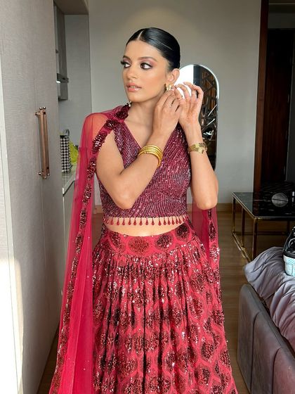 She looks like an absolute dream in this deep red lehenga. The sleek hair and sharp makeup create a very modern and chic look for any evening celebration.