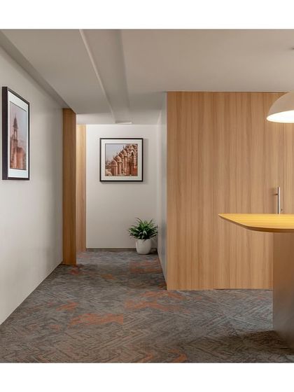 A quiet corner in 'The Office with A View' featuring a high table for informal meetings. The space is located near the wellness zone and provides a spot for quick, stand-up discussions away from the main work floor.