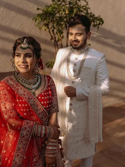 The bride and groom in a sun-drenched outdoor setting, capturing a candid moment of happiness.