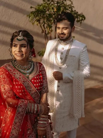 The bride and groom in a sun-drenched outdoor setting, capturing a candid moment of happiness.
