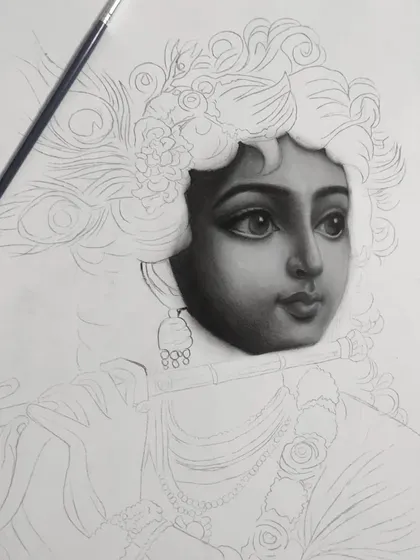 The first work-in-progress stage of my Krishna charcoal drawing. Here, the face is almost fully rendered, contrasting with the empty outline of the rest of the figure.