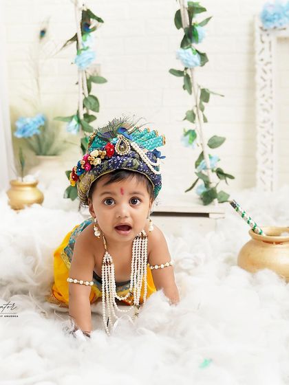A modern take on the classic Krishna theme. This little one is crawling through a sea of fluffy white clouds, with a beautiful peacock crown and pearl necklaces.