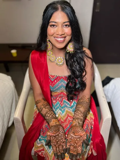 Showing off the completed Mehendi. The makeup is soft and glowing, letting the intricate henna art take center stage.