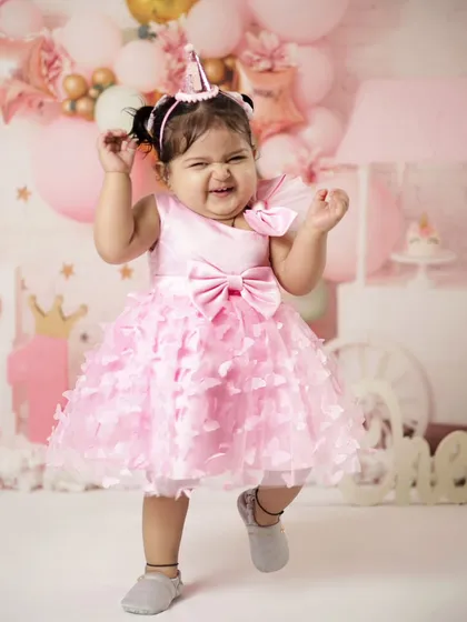 This little girl is making the cutest scrunchy face! Her personality is shining through in this pink-themed first birthday setup.