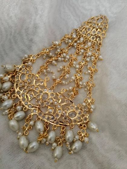 A stunning gold-plated Hyderabadi 'झूमर' (Jhumar) or 'पासा' (Paasa). This traditional hair accessory is worn on the side of the head for a touch of Nawabi elegance.