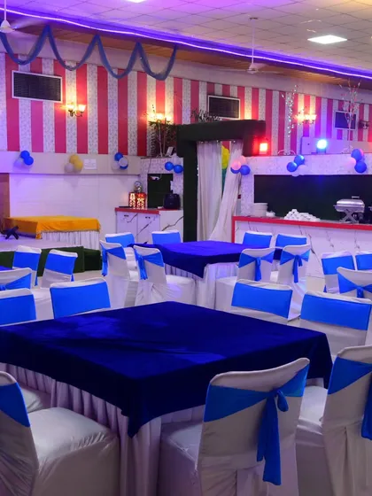 A wide shot of the hall with the blue and white theme, showing how the seating, buffet, and stage areas are all part of the overall decor.