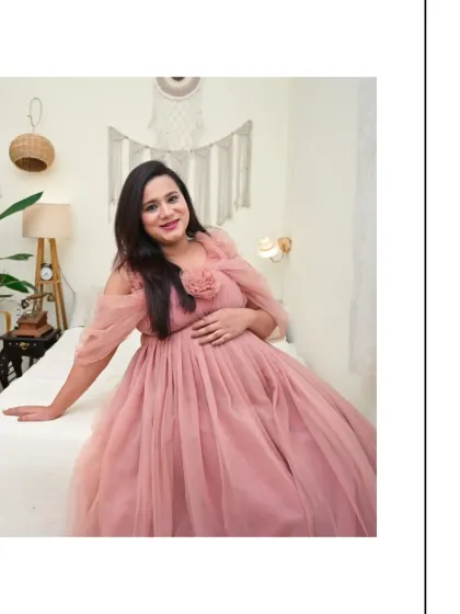 A bright and happy solo portrait in our Boho bedroom set. The mom-to-be is wearing a lovely pink tulle gown, and her smile radiates pure joy.