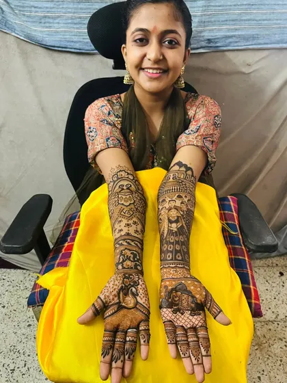 A happy bride showing off her custom portrait mehndi. We ensure you are comfortable throughout the process and are thrilled with the final result that tells your story.