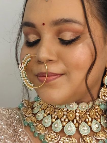 A close-up of the bride's eye makeup and the intricate details of the nath.