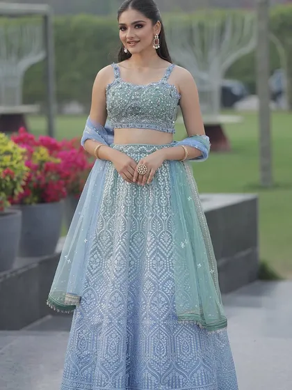 An ice blue lehenga perfect for summer weddings. The delicate embroidery and fresh color palette create a light and airy look, ideal for a daytime event.