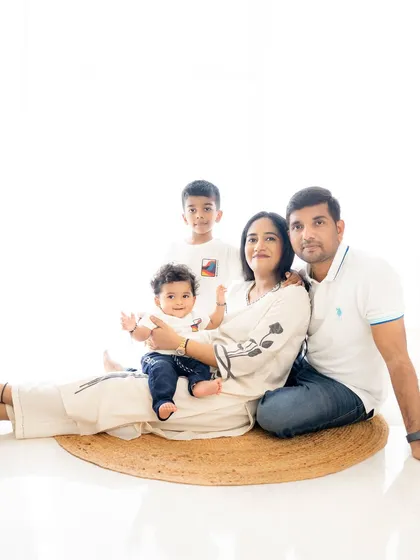 A relaxed family photo on the floor. This casual arrangement feels intimate and fun, showing the family's playful side in a bright studio setting.