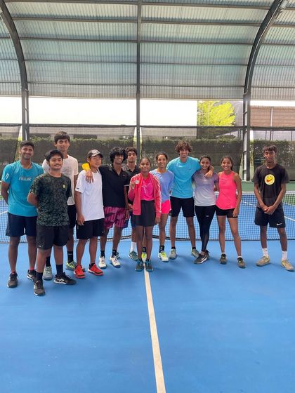 The team gathers to celebrate Sanmitha's success. This group photo shows the supportive environment that helps our young players thrive.