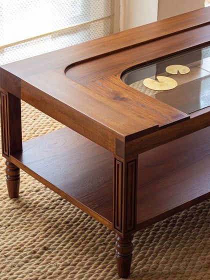 Different views of the Kulam collection, including the side table and center table. These images showcase the blend of solid teak, glass, and narrative brass accents that define this collection.