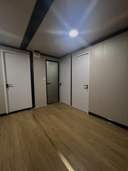This image shows the hallway and doors inside one of our modular units. The clean white doors and wood-laminate flooring create a bright and modern feel throughout the space.