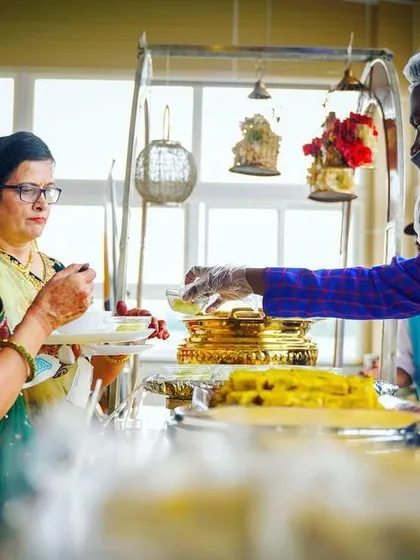 My staff member serving a sweet dish to guests at a buffet. A friendly smile and attentive service are just as important as the food itself.