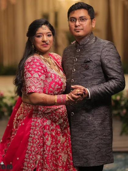 The happy couple. Our client's grey achkan provides a distinguished and elegant look that perfectly complements the bride's attire.